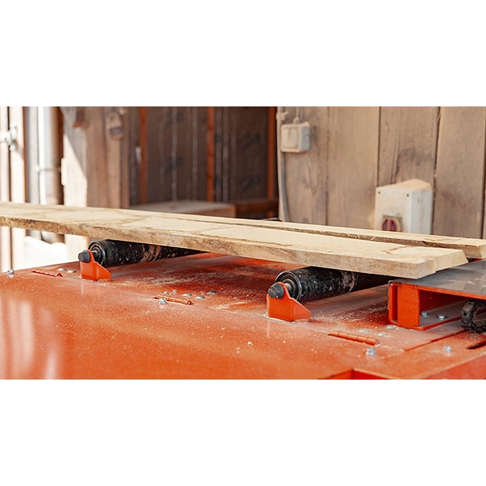 Wood-Mizer EG300 top rollers holding a board against the feed